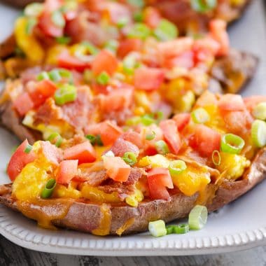 Scrambled Egg and Bacon Sweet Potato Skins on white platter by eggs