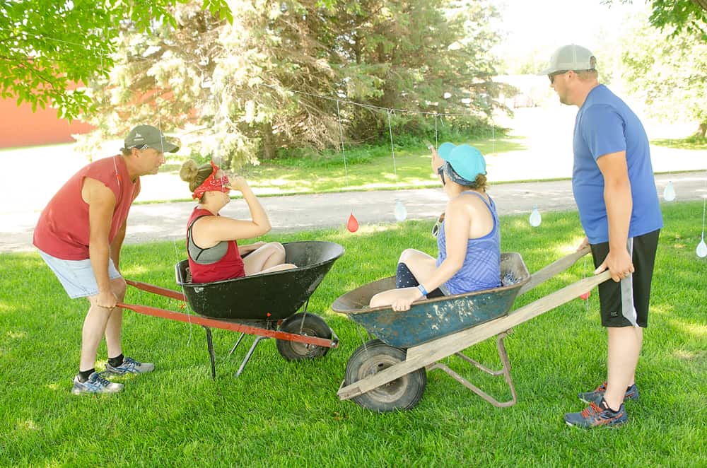 Water balloon relay pop in wheelbarrows