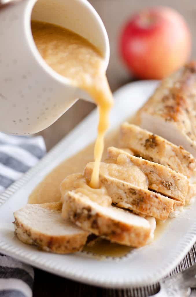 Pressure Cooker Pork Loin with Bourbon Apple Sauce in Instant Pot with apple sauce pouring over meat