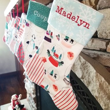 homemade personalized Christmas stockings hanging on fireplace mantel