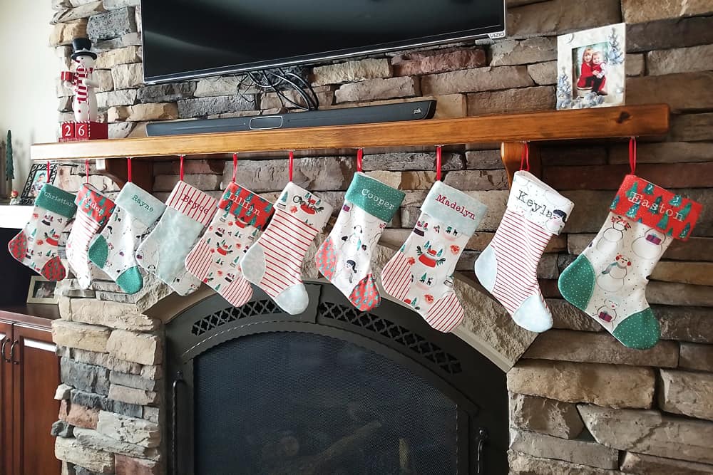 homemade personalized Christmas stockings hanging on fireplace mantel 