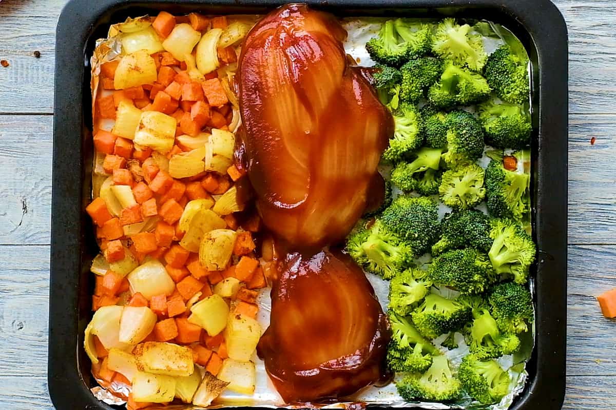 BBQ chicken breasts on sheet pan with broccoli and sweet potatoes