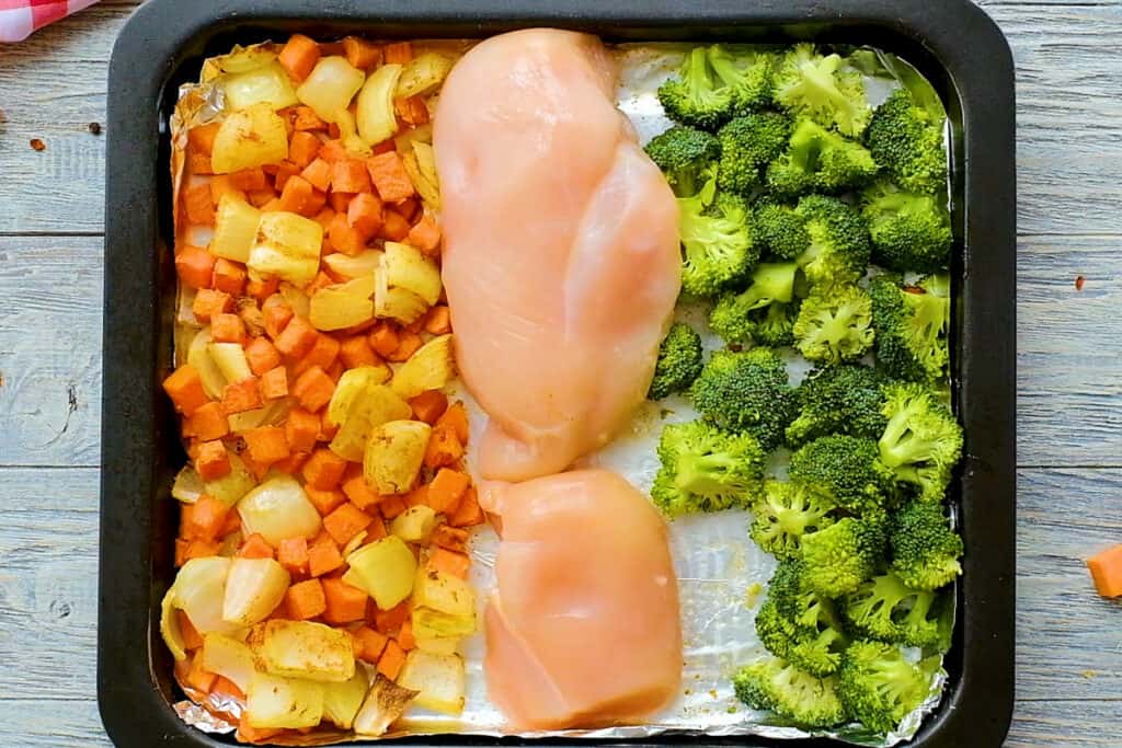 chicken breasts, onions, chipotle sweet potatoes and broccoli on lined sheet pan