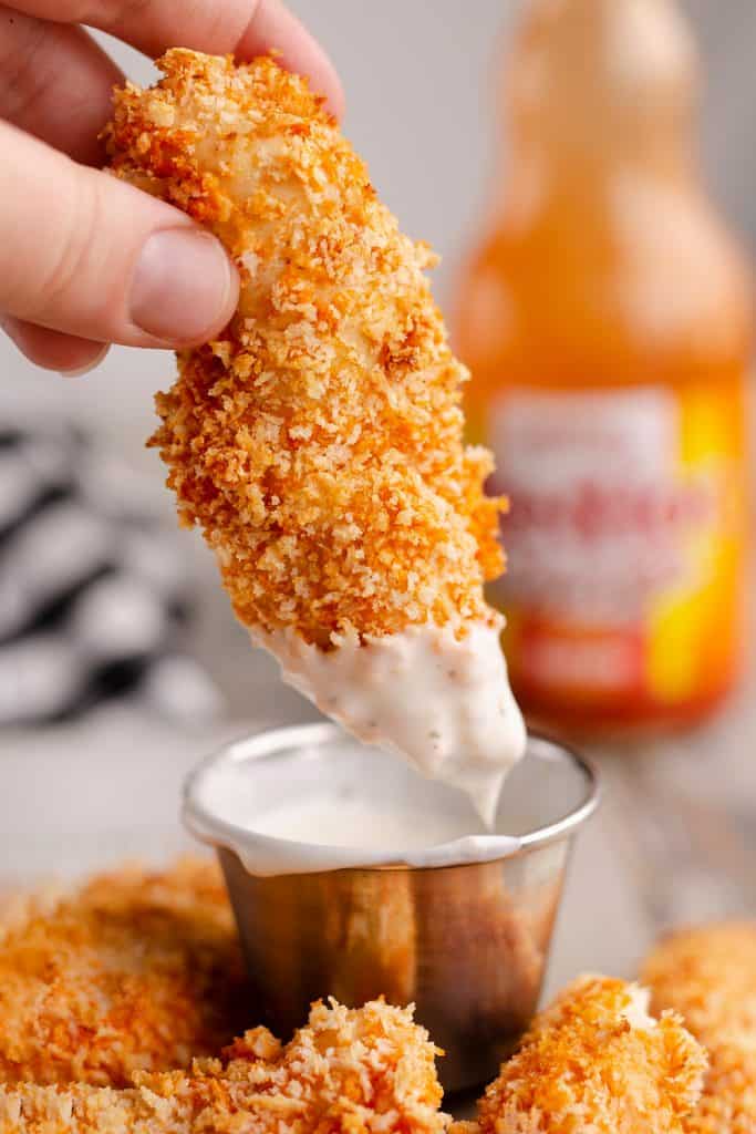 Air Fryer Buffalo Chicken Strips dipped in ranch dressing