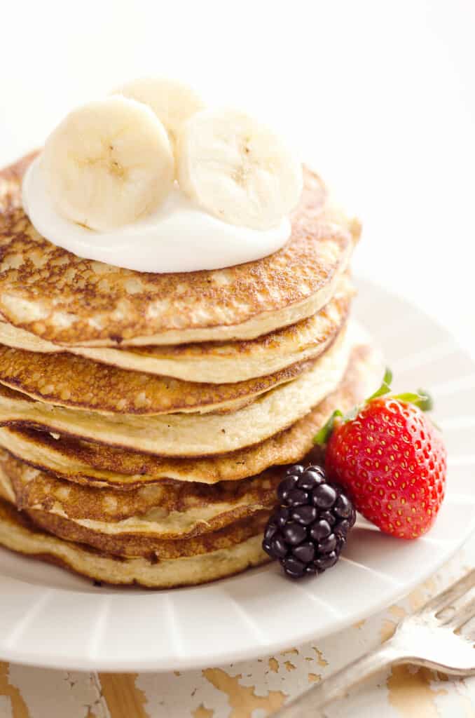 stack of protein pancakes topped with yogurt and bananas