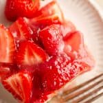 strawberry square with fork and fresh strawberry on plate