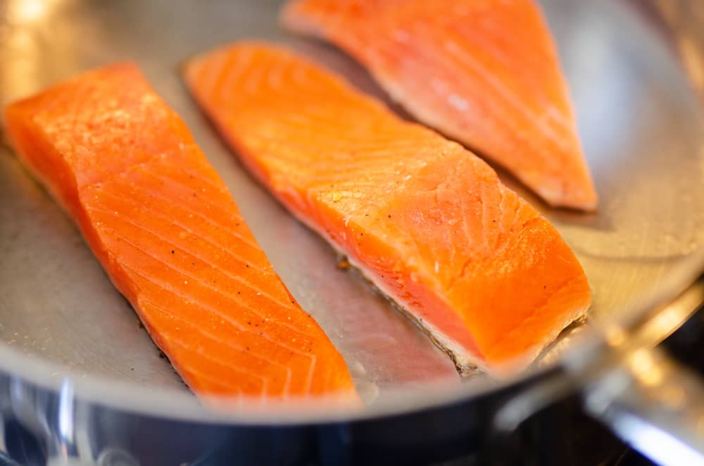 fresh salmon cooking in skillet