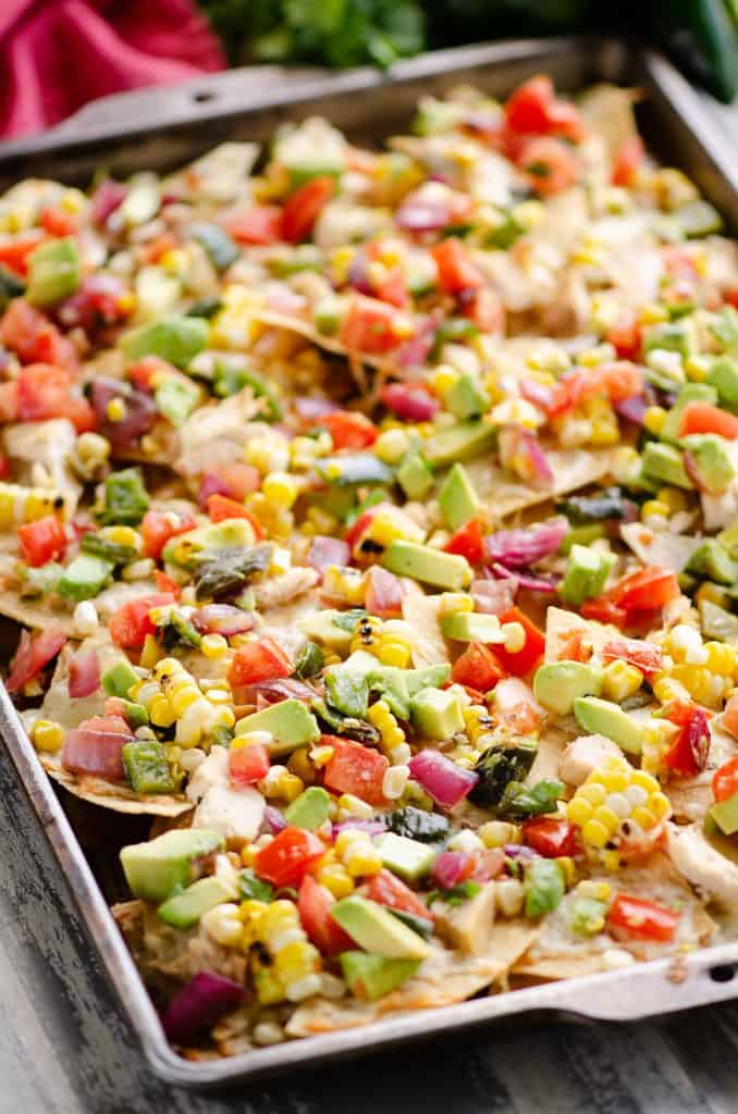 Avocado Corn Chicken Nachos baked on sheet pan