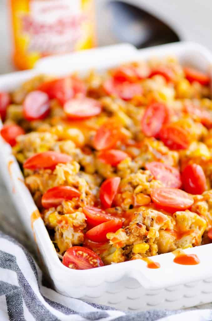 Pressure Cooker Buffalo Chicken Quinoa in casserole topped with tomatoes and sauce