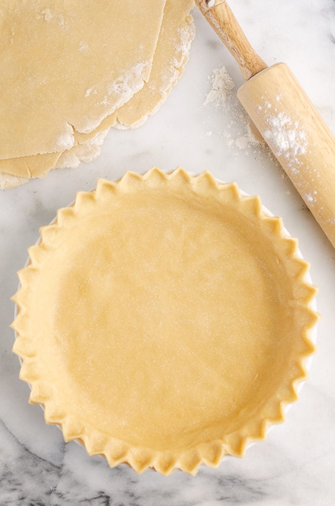 Flakey Pie Crust on marble counter with floured rolling pin