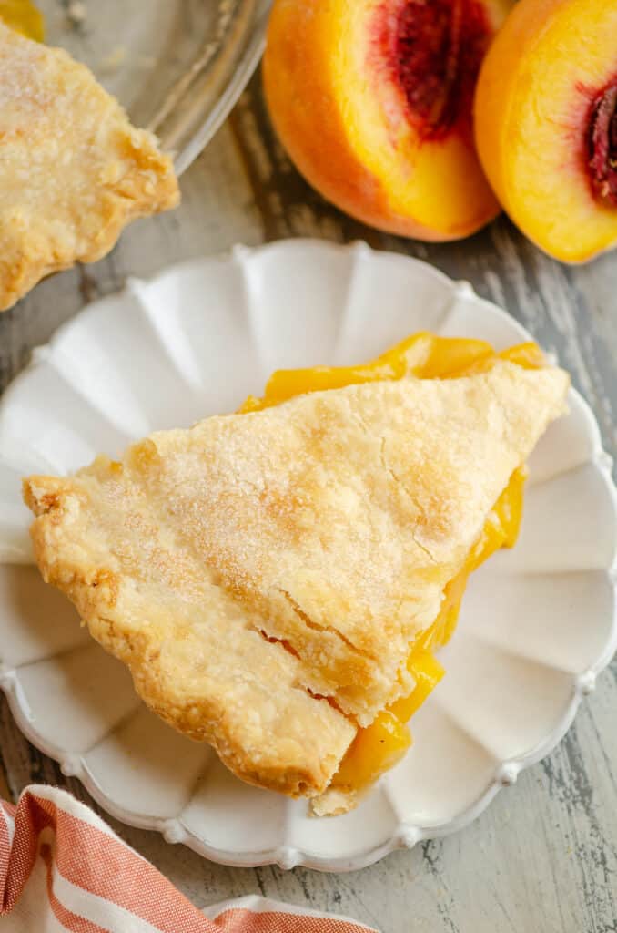 slice of peach pie served on scalloped plate