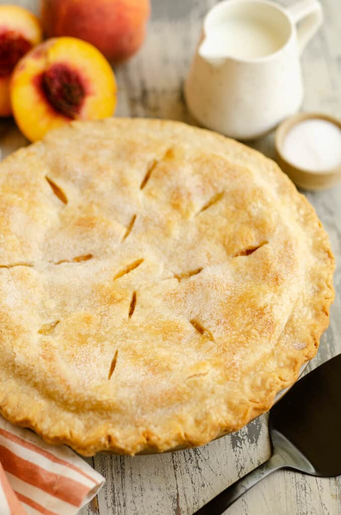 peach pie with flakey crust in pan