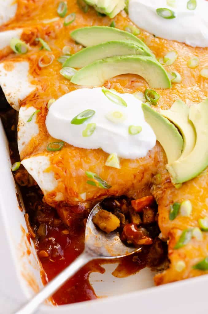 Black Bean & Squash Vegetarian Enchiladas served wtih sour cream and avocado