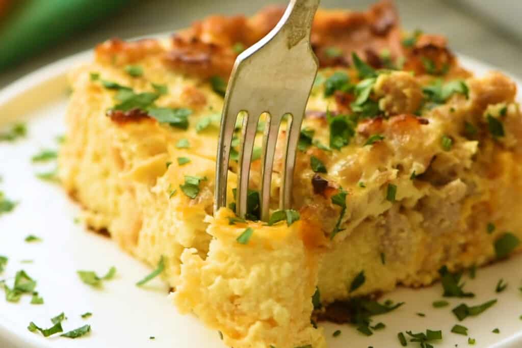 bite of overnight sausage egg casserole from plate with fork