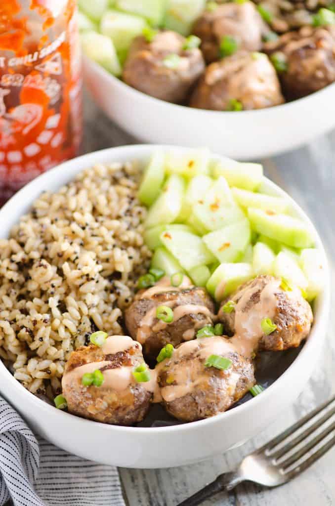 Honey Sriracha Meatball Bowls with a bottle of sriracha