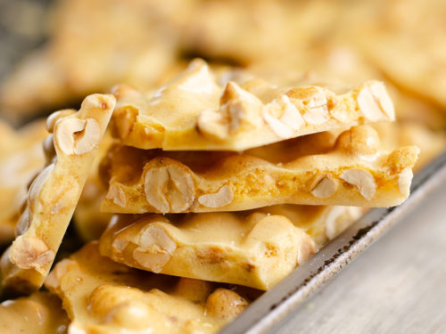 peanut brittle stacked on baking pan