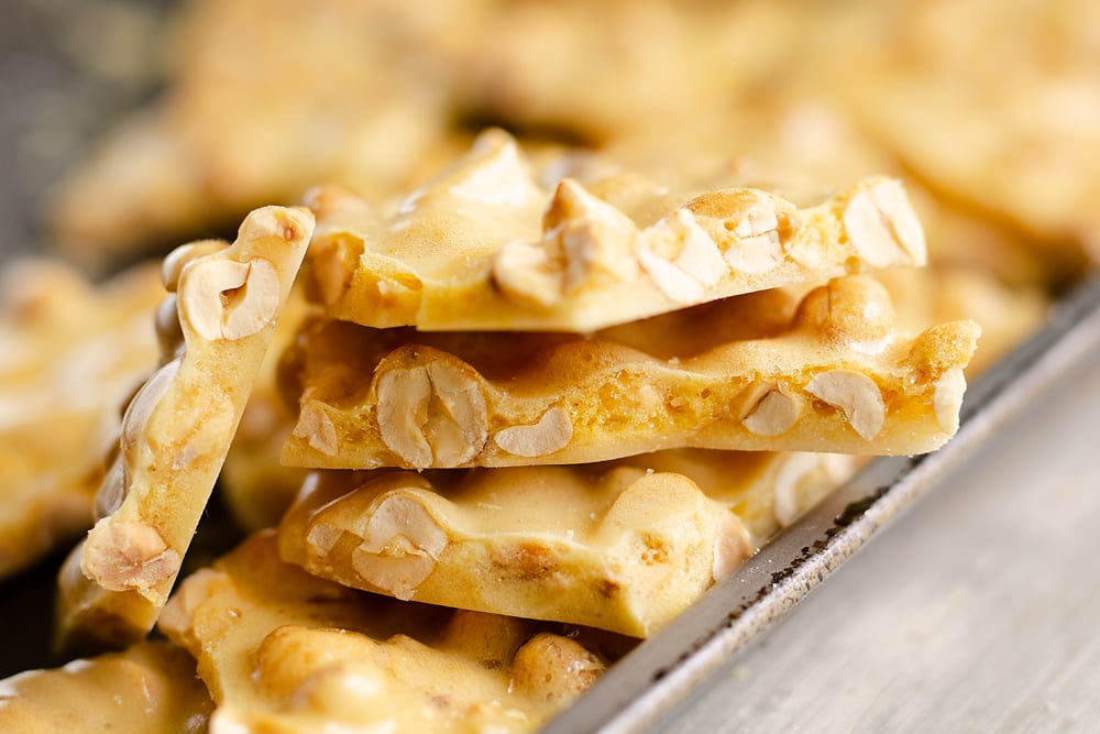 peanut brittle stacked on baking pan