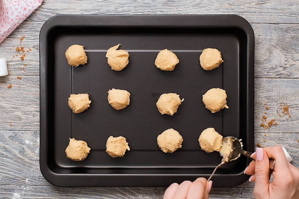 dropping cookies by spoon on cookie sheet