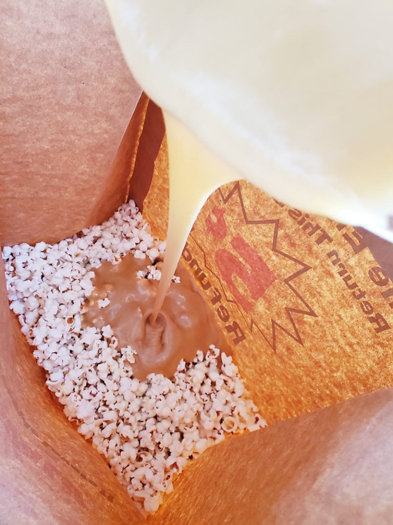 Popcorn in a brown paper bag with microwave caramel sauce