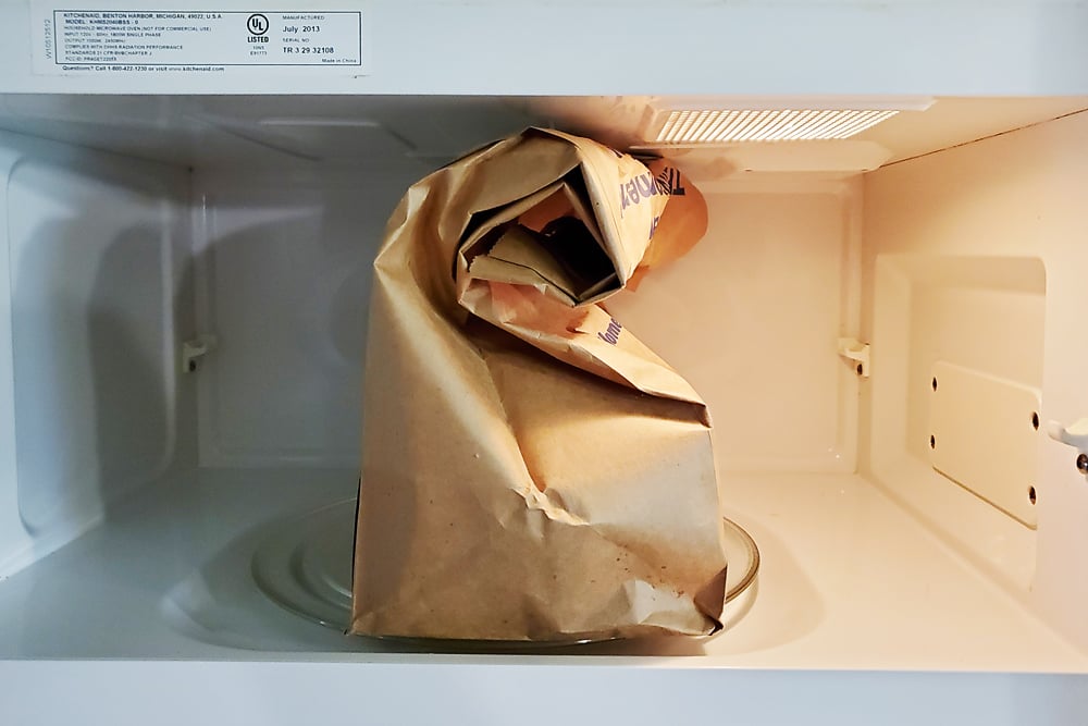 Microwave Caramel Popcorn in a brown paper bag cooking in microwave