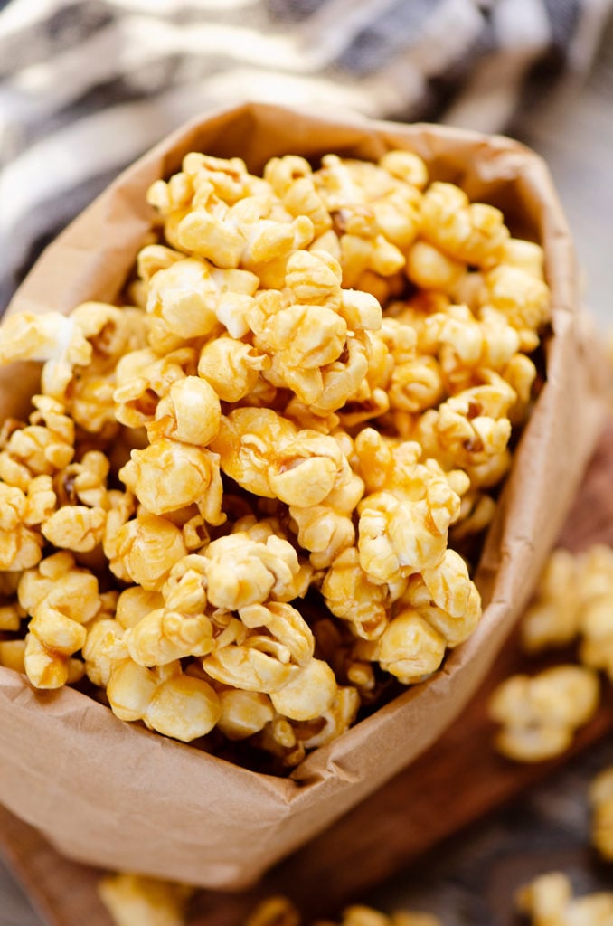 Microwave Caramel Popcorn in a brown paper bag on cutting board