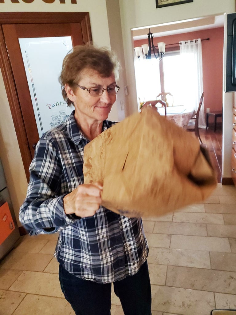 grandma shaking microwave caramel popcorn in brown paper bag