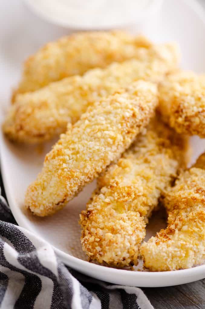 Air Fryer Chicken Strips piled on white plate