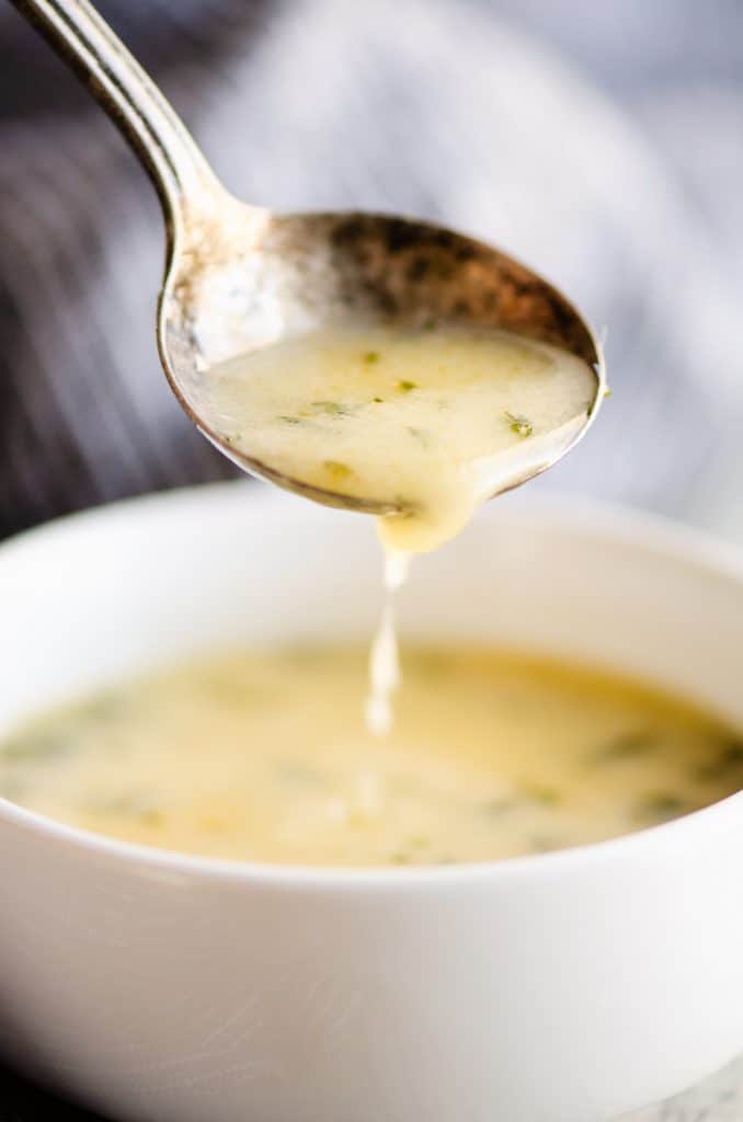 Lemon Butter sauce in small bowl with spoonful dripping