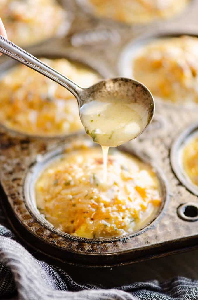 Buttery Tuna Rice Muffins in muffin tin being topped with spoonful of lemon butter sauce