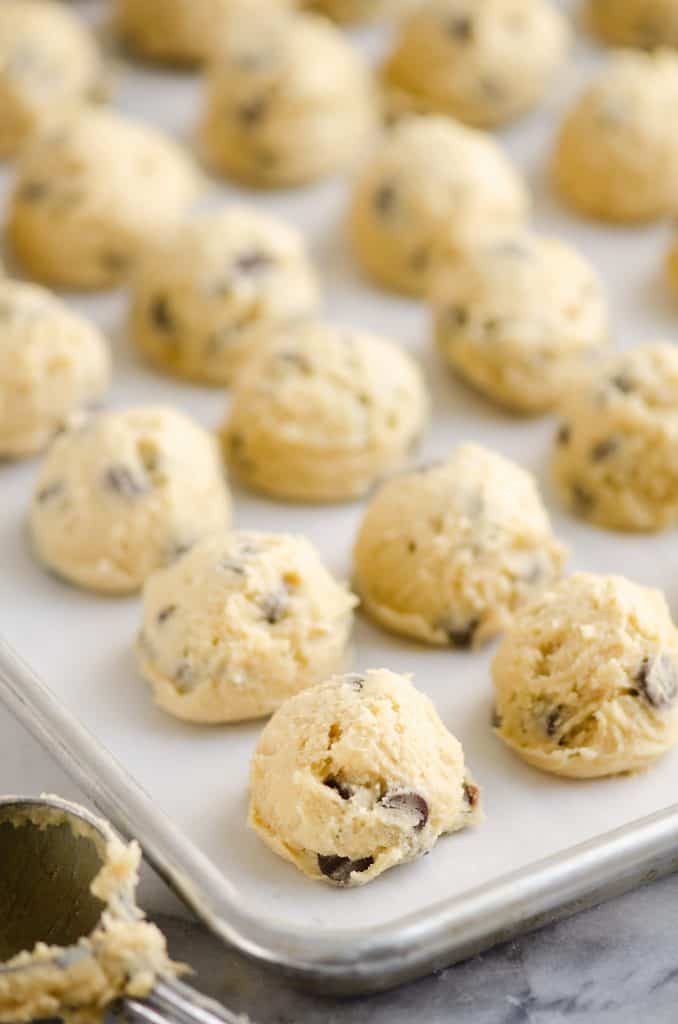 Frozen Chocolate Chip Cookie Dough Pucks on cookie sheet with parchment paper