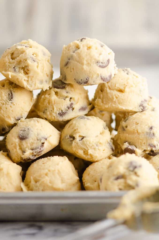 Frozen Chocolate Chip Cookie Dough Pucks stacked on cookie sheet