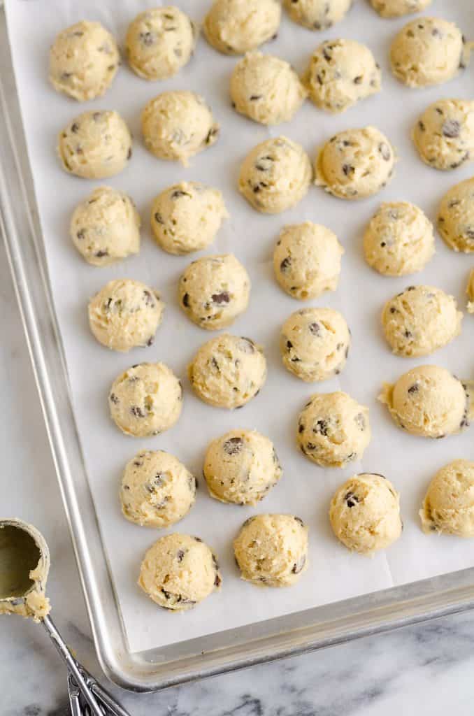 Frozen Chocolate Chip Cookie Dough Pucks arranged on cookie sheet