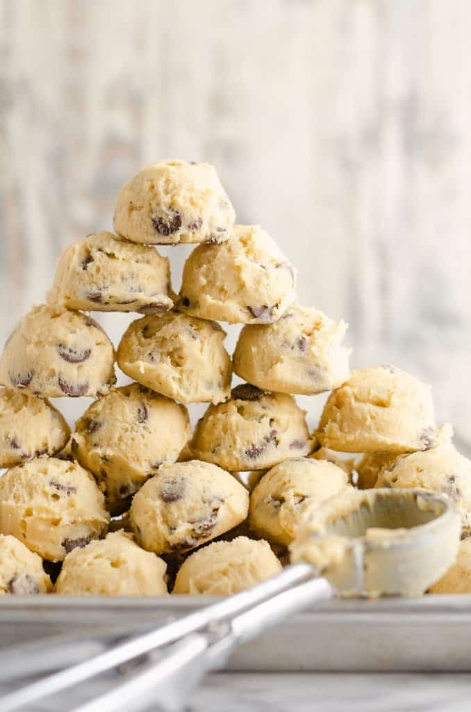 Frozen Chocolate Chip Cookie Dough Pucks stacked on cookie sheet