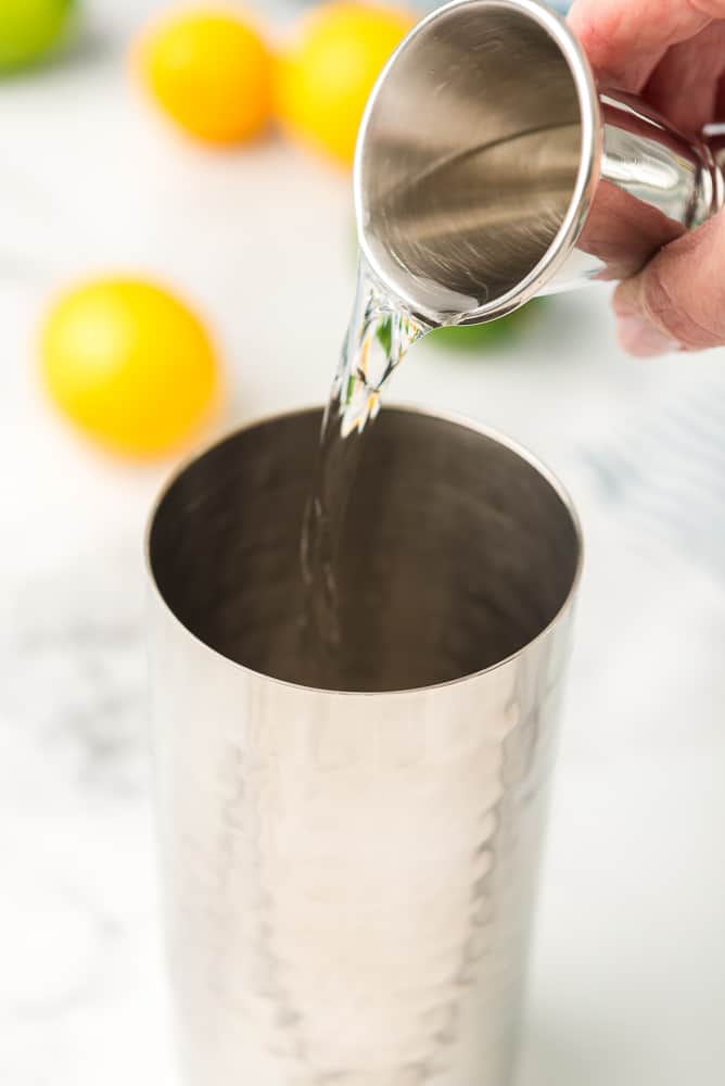 shot of clear liqueur poured into cocktail shaker