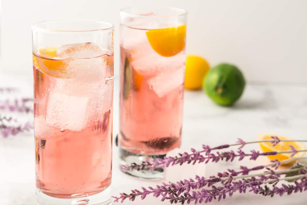 Purple Rain Cocktail on table with citrus fruits