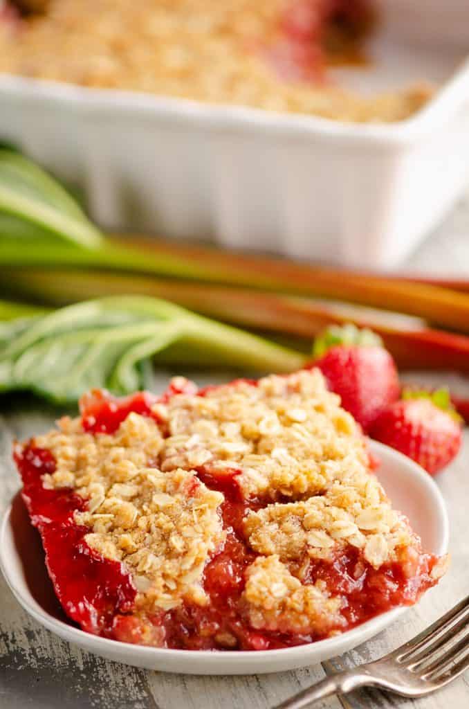 Strawberry Rhubarb Crisp Bars on white plate on table with fork