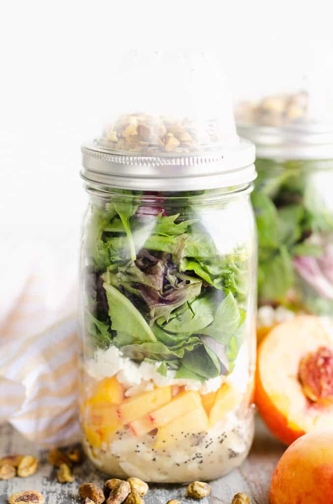 Chicken Peach Salad in a Jar on table with napkin and half peaches