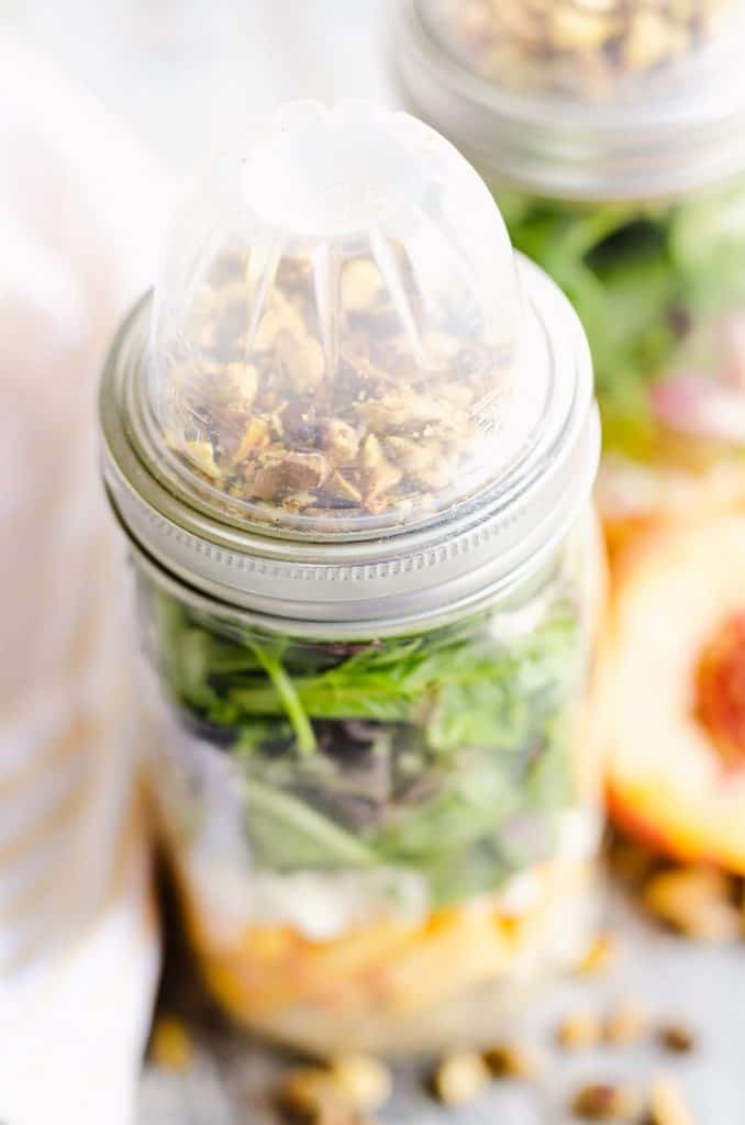 Chicken Peach Salad in a Jar topped with container of pistachios