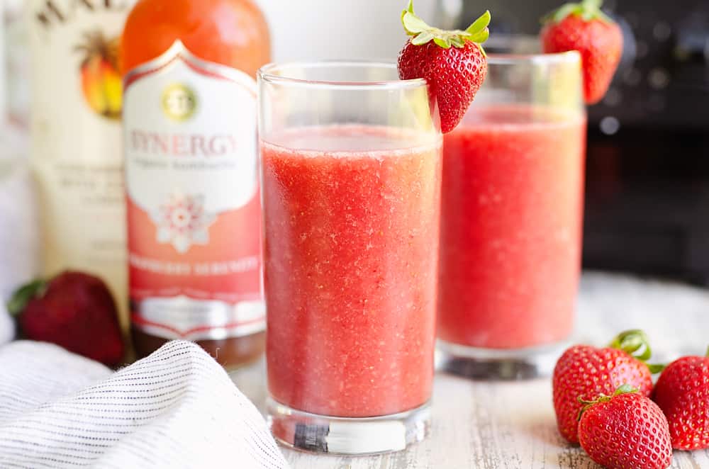 Frozen Strawberry Malibu Kombucha Cocktails on table with blender and strawberries