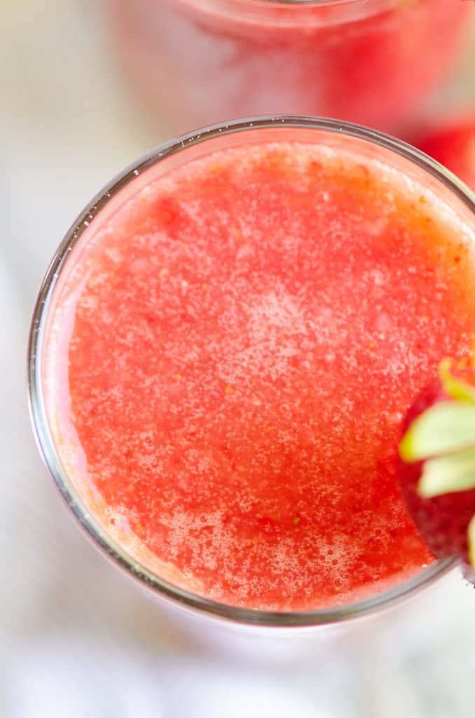 Frozen Strawberry Malibu Kombucha Cocktail in clear glass on table