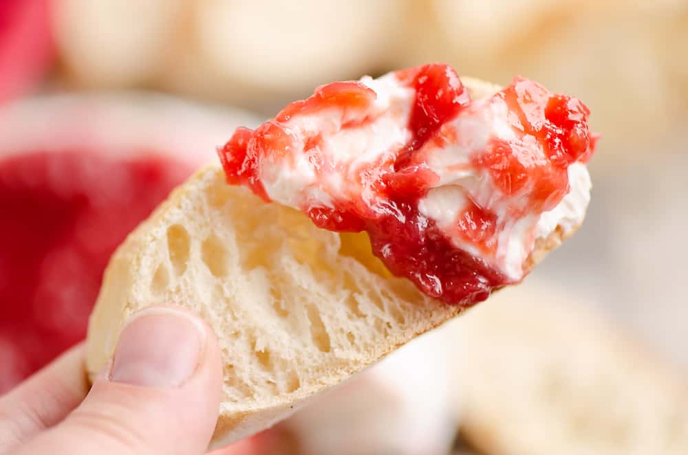 Whipped goat cheese topped with a rhubarb sauce swirled on a piece of French bread