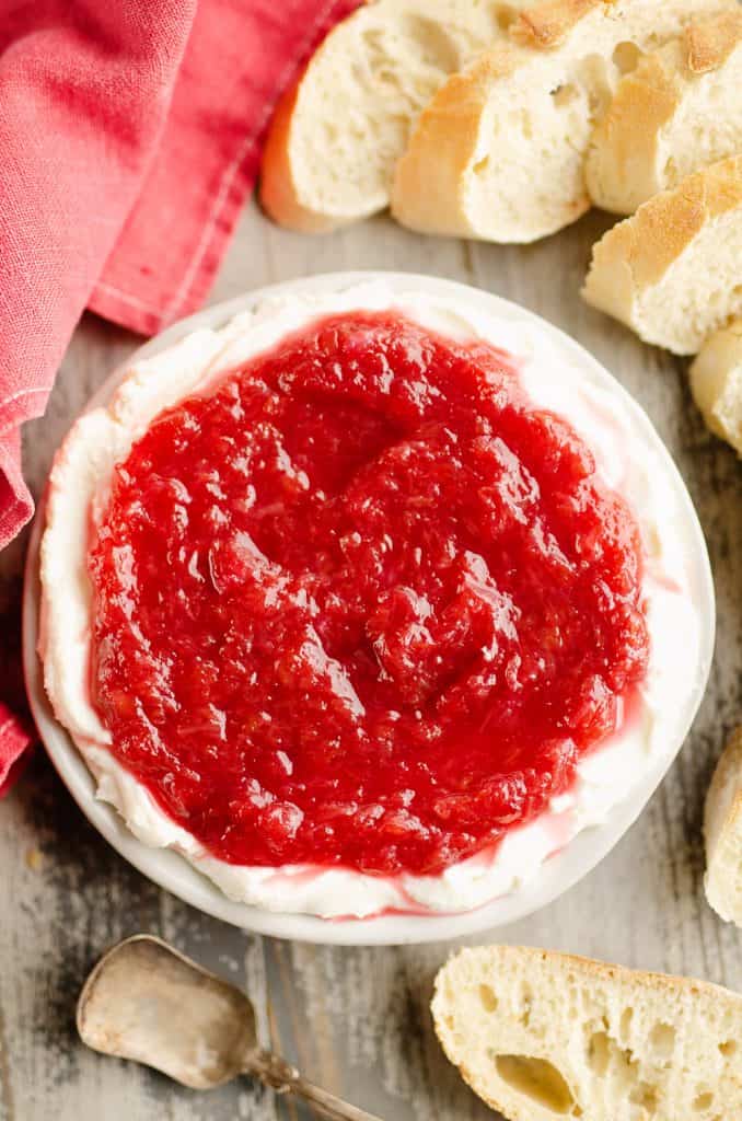 Whipped goat cheese topped with a rhubarb sauce served on a small appetizer plate with French bread