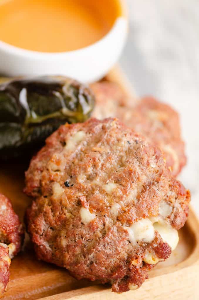 Smoked Cheese Curd Burger on cutting board with pepper and dressing