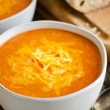 white bowl of tomato soup with bread