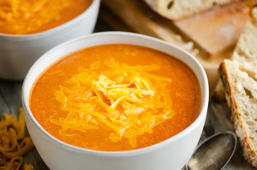 white bowl of tomato soup with bread