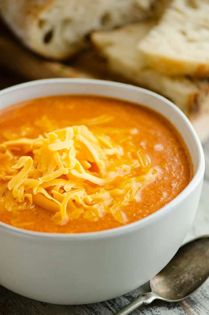 white bowl of tomato soup with bread