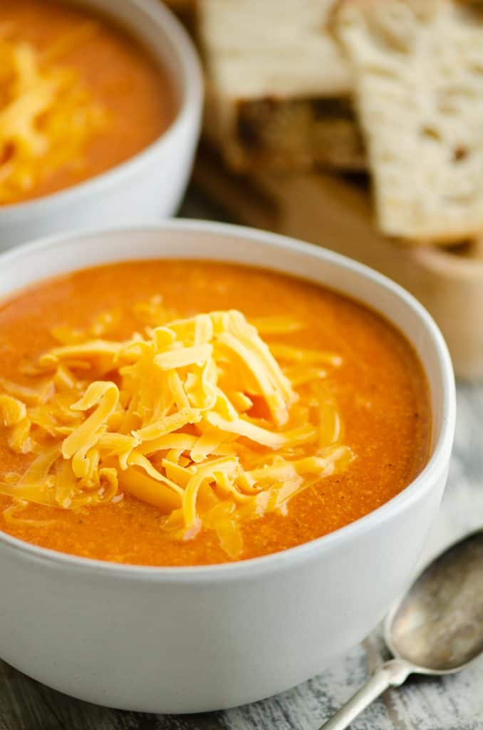 white bowl of tomato soup with bread