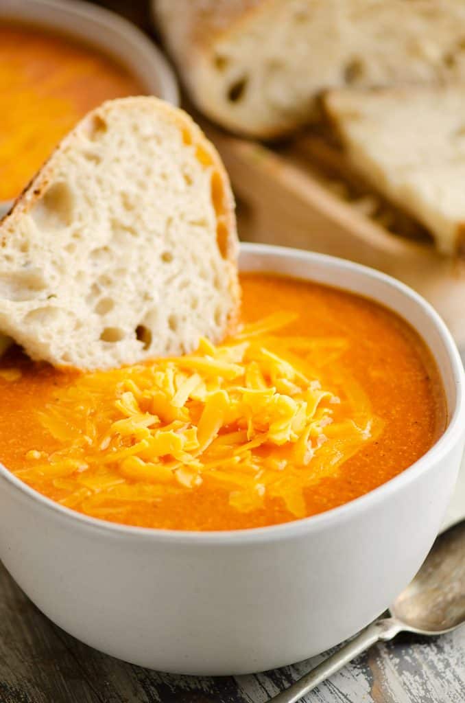 white bowl of tomato soup with bread