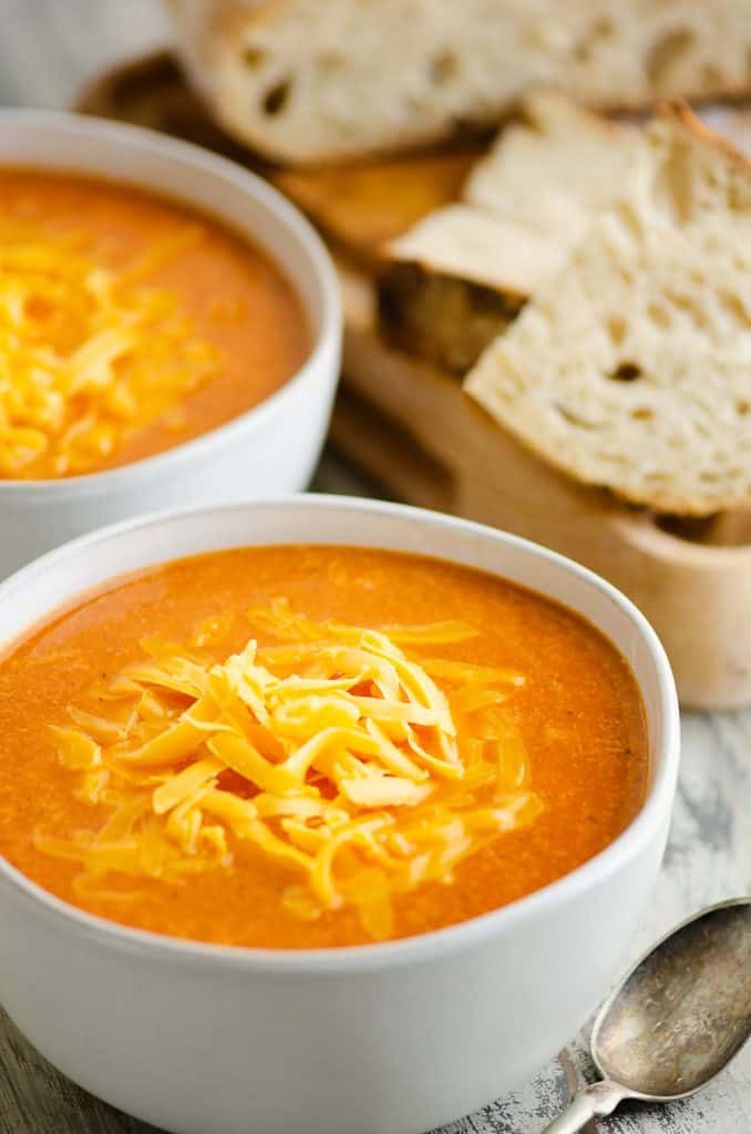 white bowl of tomato soup with bread