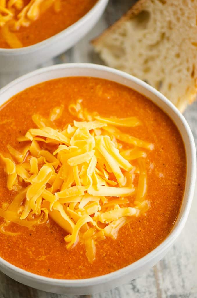 white bowl of tomato soup with bread